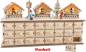Preview: Adventskalender mit vierundzwanzig kästchen oben drauf drei Weihnachtsmarktstände ein Baum eine Laterne und zwei Winterfiguren