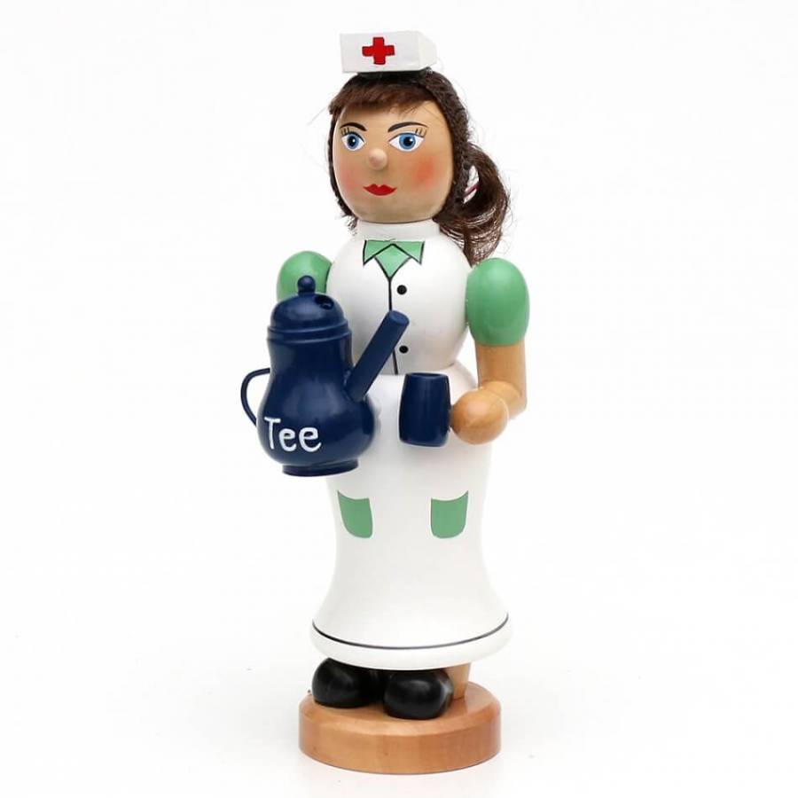 Räucherfigur raeuchermaennchen Krankenschwester mit weißer Kappe mit rotem Kreuz weißem Kleid mit grünen Ärmeln und Taschen. Mit blauer Teekanne und blauem Becher