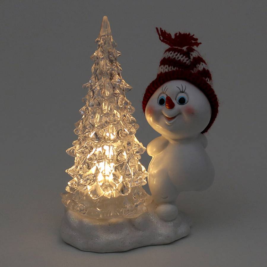 leuchtender-LED-Tannenbaum-daneben-Schneekind-mit-roter-Strickmütze